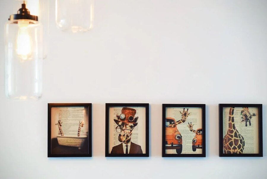 four paintings of a giraffe mounted on the wall