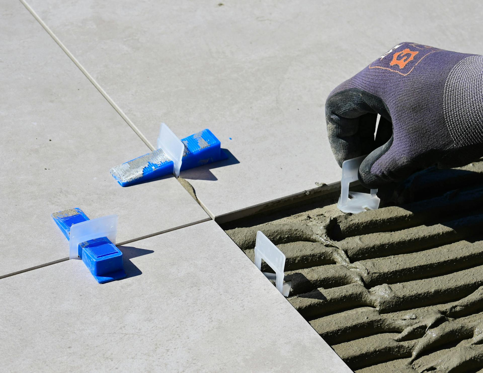  An individual operating a tile cutting tool, demonstrating skill in cutting a tile accurately.